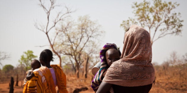 A woman and her child from the Nuba Mountains in Sudan walk outside of the Yida refugee camp registration center in Yida, South Sudan, on April 25, 2012. After an initial attack by SPLA-N rebel forces in South Kordofan, thousands of people from the Nuba Mountains have fled to neighboring Yida to escape the fighting and retaliatory airstrikes by Khartoumâs Sudan Armed Forces (SAF). AFP / Adriane Ohanesian (Photo credit should read ADRIANE OHANESIAN/AFP/GettyImages)