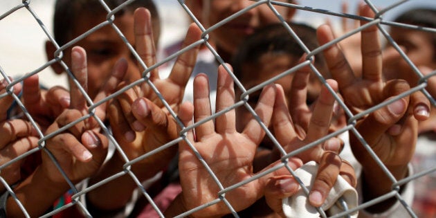 Syrian refugee children wave and flash the V-sign at a refugee camp in Suruc, on the Turkey-Syria border, Friday, June 19, 2015. Ahead of World Refugee Day on Saturday, June 20, 2015, the UN refugee agency, UNHCR, estimated that a total of 11.6 million people from Syria had been displaced by the conflict by the end of last year, the largest such figure worldwide. Turkey is the world's biggest refugee host with 1.59 million refugees, according to the most recent U.N. figures. (AP Photo/Emrah Gurel)