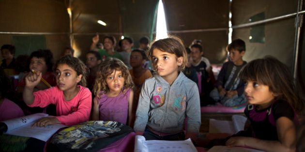 In this Tuesday, Aug. 11, 2015 file photo, Syrian refugee children attend a class at a makeshift school set up in a tent at an informal tented settlement near the Syrian border on the outskirts of Mafraq, Jordan. Forty percent of children from five conflict-scarred Middle Eastern countries are not in school, the U.N. child welfare agency said in a report Thursday, Sept. 3, 2015, warning of a lost generation and a dim future for the region. UNICEF said 13.7 million out of 34 million school age children in Syria, Iraq, Yemen, Libya and Sudan are not getting an education, almost double the number five years ago. (AP Photo/Muhammed Muheisen, File)