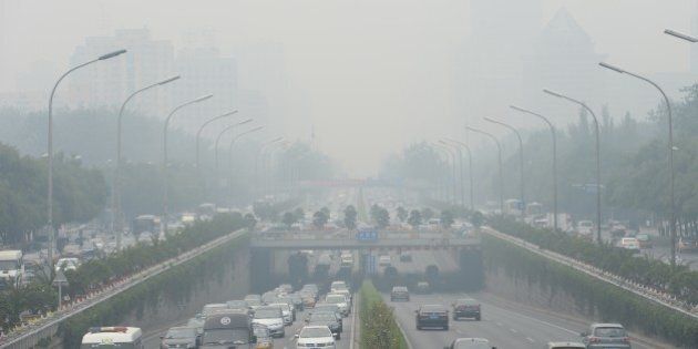 This picture taken on June 23, 2015 shows vehicles running in smog covered streets in Beijing. China's cities are often hit by heavy pollution, blamed on coal-burning by power stations and industry, as well as vehicle use. The issue has become a major source of popular discontent with the Communist Party, leading the government to vow to reduce the proportion of energy derived from fossil fuels. CHINA OUT AFP PHOTO (Photo credit should read STR/AFP/Getty Images)