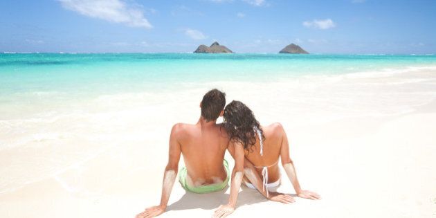 couple on beach vacation enjoying sun on honeymoon. Lanikai beach and the Mokulua islands in kailua, oahu, hawaii