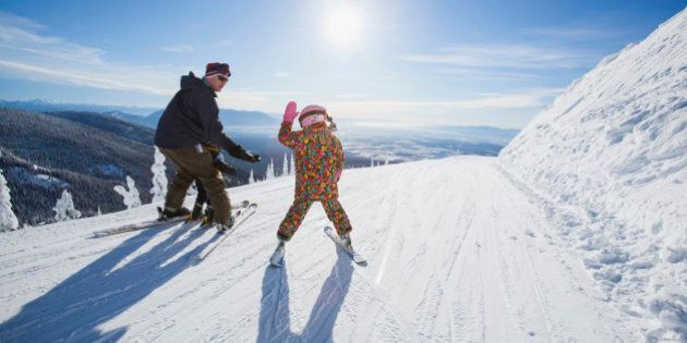 USA, Montana, Whitefish, Father skiing with children (6-7, 8-9)