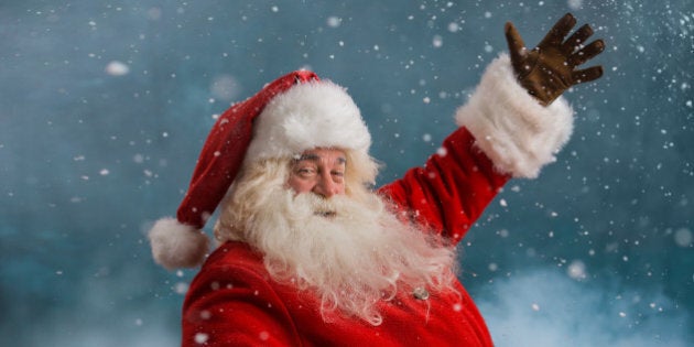 Happy Santa Claus laughing while standing outdoors at North Pole