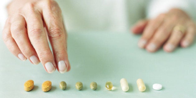 Mature woman arranging pills in row