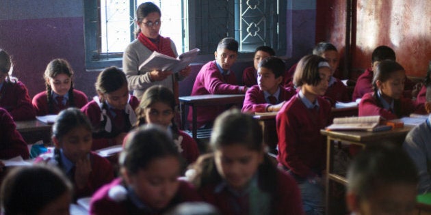 In a picture taken on November 21, 2012, Drishti Silwal (back row L), a 12 year old Brahmin Nepali girl reads a book at school in Kathmandu. Dristhi returned to school after spending 7 days staying in the darkness of her bedroom as part of an isolation ritual during her first menstruation. Usually Brahmans stay isolated for 21 days in the dark, without the permission to look outside, see any men, pray or cook, but in modern families the ritual can be reduced to 7 days and Drishti was allowed to read. AFP PHOTO / MATTHIEU ALEXANDRE (Photo credit should read MATTHIEU ALEXANDRE/AFP/Getty Images)