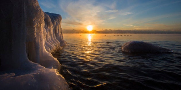 TORONTO, ON - JANUARY 23: A half moon lingers in the sky as the sun reflects off ice formations on the Lake Ontario shoreline at Len Ford Park, Etobicoke. Although the snow did not come as predicted in the GTA, the temperature remains in the minus double digits. January 23, 2014. (Bernard Weil/Toronto Star via Getty Images)