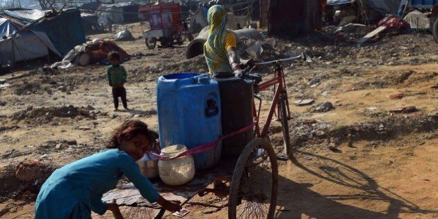 This photo taken on March 19, 2015 shows a girl helping her mother carrying water containers on a tricyle rickshaw to their shanty in Ghaziabad, east of New Delhi. A new UN report launched in New Delhi on March 20 ahead of World Water Day on March 22 warned of an urgent need to manage the world's water more sustainably and highlight the problem of groundwater over-extraction, particularly in India and China. The report says global demand for water is increasing exponentially, driven largely by population growth. AFP PHOTO/ PRAKASH SINGH (Photo credit should read PRAKASH SINGH/AFP/Getty Images)