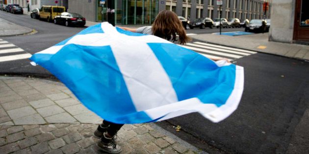 A young girl runs around a street pole with a Scottish national flag before taking part in a demonstration in favor of Scottish independence in Brussels on Thursday, Sept. 18, 2014. Scots held the fate of the United Kingdom in their hands Thursday as they voted in a referendum on becoming an independent state, deciding whether to unravel a marriage with England that built an empire but has increasingly been felt by many Scots as stifling and one-sided. (AP Photo/Virginia Mayo)