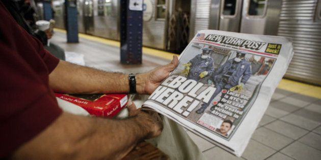 NEW YORK, NY - OCTOBER 24: A man shows the front page of a local newspaper while reading in the subway on October 24, 2014 in New York City. Dr. Craig Spencer, who returned to New York from Guinea 10 days ago, tested positive for Ebola on October 23 and is now being cared for at Bellevue Hospital. Spencer, a member of Doctors Without Borders, rode the subway after returning home. (Photo by Kena Betancur/Getty Images)