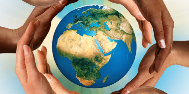 Conceptual symbol of multiracial human hands surrounding the Earth globe. Unity, world peace, humanity concept.