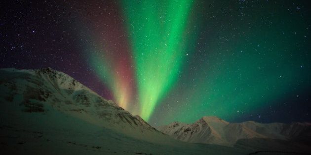 Aurora borealis ( northern lights ) above Alaskan Mountain. This shot was taken at Atigun Pass, Dalton Highway, Alaska, USA