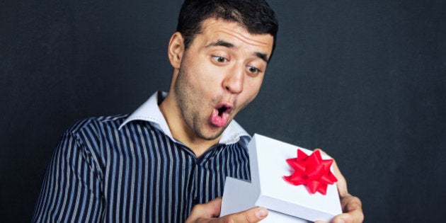 Surprised man opening big gift box