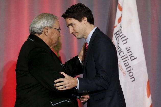 Prime Minister Justin Trudeau, right shakes hands with Justice Murray Sinclair during the release of the Truth and Reconciliation Commission's final report in Ottawa, on Dec. 15, 2015.