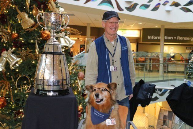 George Ames and Rusty pose with the Grey Cup.