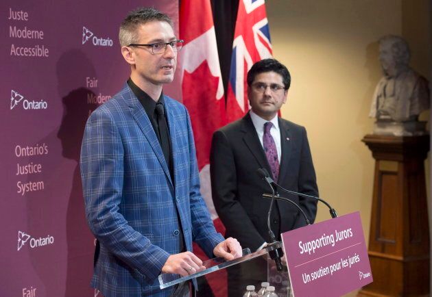 Former Ontario Attorney General Yasir Naqvi (right) listens as Mark Farrant speaks at the announcement of a juror support program in Hamilton, Ont. of the on Jan. 31, 2017.