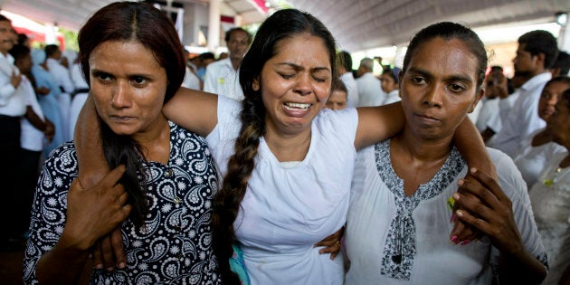 A grieving woman is supported during a funeral service at St. Sebastian Church in Negombo, Sri Lanka, for Easter Sunday bomb blast victims on April 23, 2019. More than 320 people were killed in the attacks.