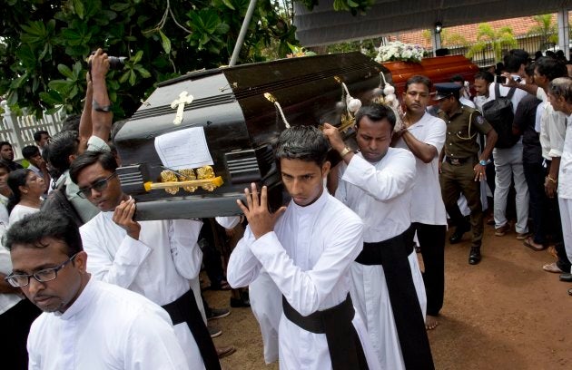 Clergymen carry coffins for burial during a funeral service for Easter Sunday bomb blast victims at St. Sebastian Church in Negombo, Sri Lanka, on April 23, 2019.