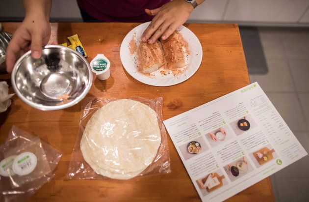 Jayne Zhou seasons fish while preparing cajun fish tacos from a Hello Fresh meal kit at her home in Vancouver in 2017.