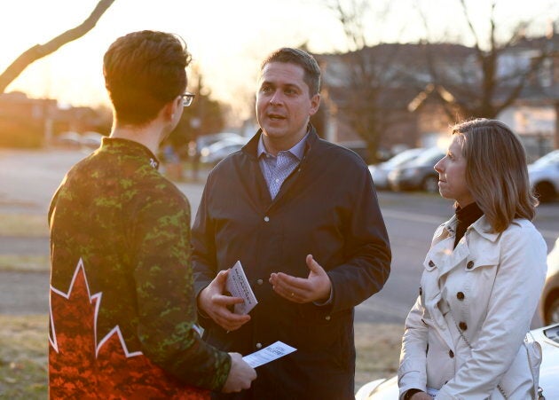 Conservative Leader Andrew Scheer speaks to a resident with Kanata—Carleton candidate Justina McCaffrey, right, during a door knocking event in the Kanata suburb of Ottawa on April 25, 2019.