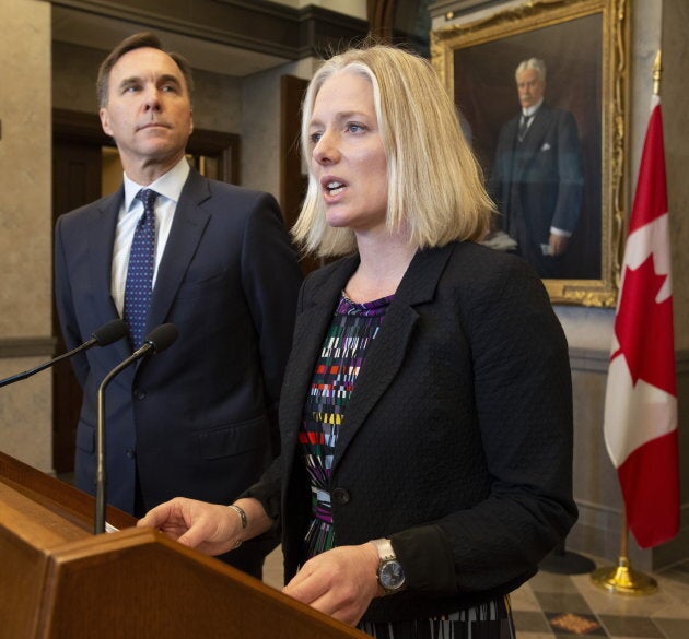 Finance Minister Bill Morneau looks on as Environment Minister Catherine McKenna speaks in the foyer of the House of Commons in Ottawa on April 29, 2019.