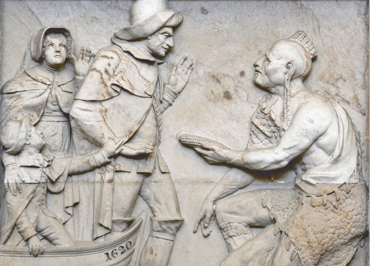 "Landing of the Pilgrims," an 1825 sandstone carving in the Capitol Rotunda, shows a Native man bowing down to a colonizer with corn as he rolls up on a ship that says 1620 on it. What?