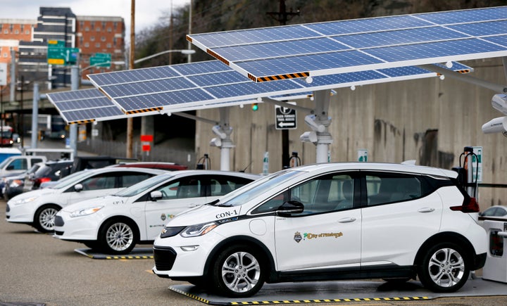 Some of the city of Pittsburgh's fleet of electrical vehicles parked under solar charging panels.