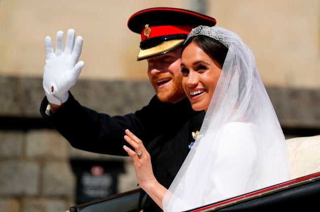 Britain's Prince Harry, Duke of Sussex and his wife Meghan, Duchess of Sussex wave from the Ascot Landau Carriage during their carriage procession on Castle Hill outside Windsor Castle in Windsor, on May 19, 2018 after their wedding ceremony.