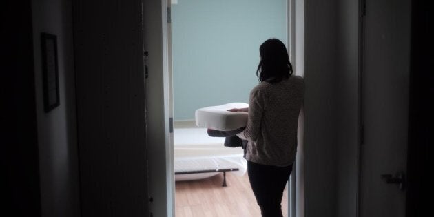 A staff member carries bedding in one of the suites at Toronto's Interval House, an emergency shelter for women in abusive situations, on Feb. 6, 2017.