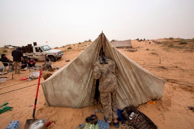 In this file photo from Feb. 21, 2015, a Libyan soldier wakes his comrade in Al Ajaylat, 120 km west of Tripoli, Libya. The work of photographer and video journalist Mohamed Ben Khalifa, who was killed in Libya on Saturday, Jan. 19, 2019, reflected Libya's post-2011 chaos of rival militias fighting for control as well as the humanitarian tragedy of waves of people fleeing North Africa, the Middle East and sub-Saharan Africa.