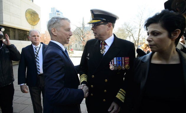 Liberal MP Andrew Leslie shakes hands with Vice Admiral Mark Norman as he arrives to court in Ottawa on May 8, 2019.