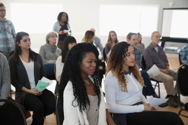 Women of colour attending a town hall meeting.