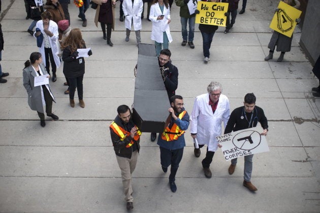 A model of a coffin is carried as physicians and health workers protest in Toronto on April, 3, 2019, as part of a National Day of Action to call for stronger gun control laws, including passage of Bill C-71 and a handgun assault weapons ban.