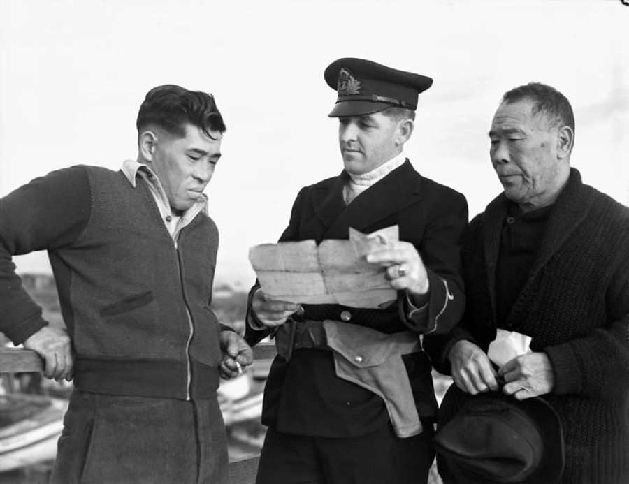 Japanese-Canadian fishermen are questioned after having their boat confiscated by a Royal Canadian Navy Officer in this undated photo.