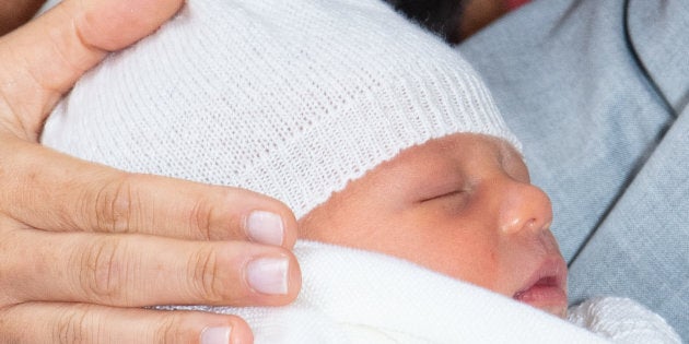 Prince Harry, Duke of Sussex and Meghan, Duchess of Sussex, pose with their newborn son Archie Harrison Mountbatten-Windsor during a photocall in St George's Hall at Windsor Castle on May 8, 2019 in Windsor, England.