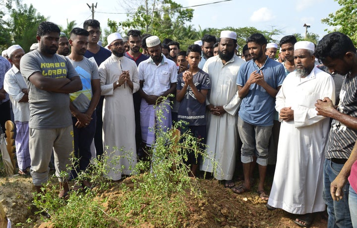 Relatives mourn beside the coffin of a victim of an anti-Muslim riots during a burial ceremony in a Muslim cemetery in Nattandiya on May 14, 2019.