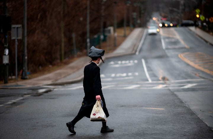 A youth crosses a street in Monsey, New York, where a measles outbreak has sickened scores of people, mainly from the Orthodox Jewish community.