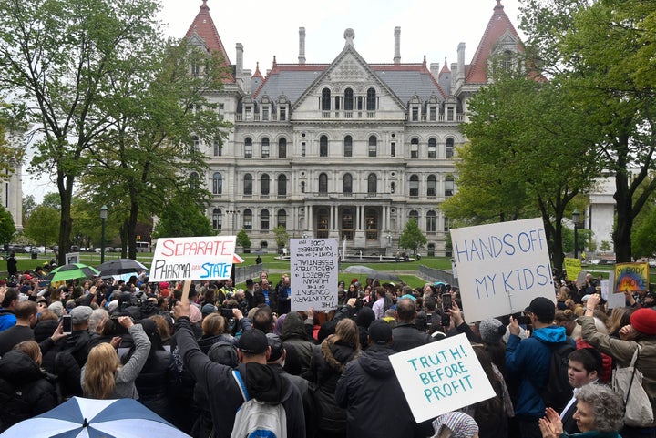 Protesters stand in the rain while protesting against legislation to narrow exemption to state-mandated vaccines at a rally at New York's state Capitol on Tuesday.