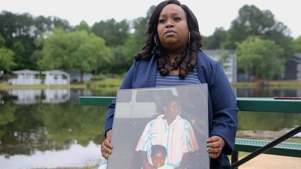 Breast cancer survivor Felicia Mahone, holding a photo of her and her mother, who died of breast cancer, has devoted her life to helping other women through the course of treatment.