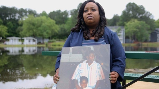 Breast cancer survivor Felicia Mahone, holding a photo of her and her mother, who died of breast cancer, has devoted her life