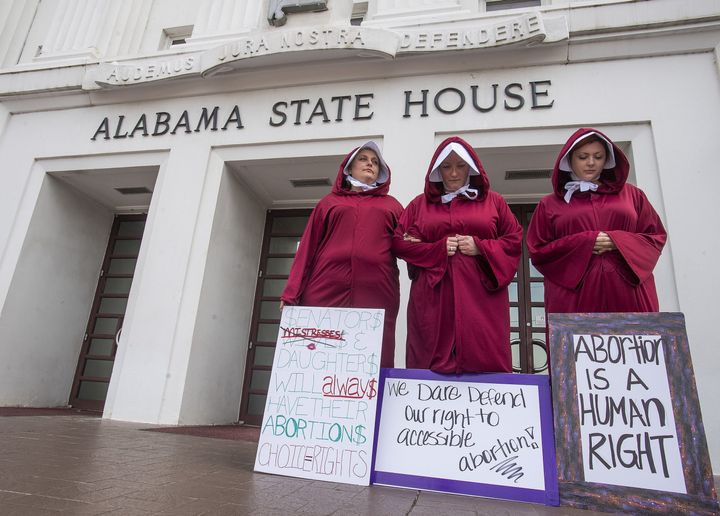 Protestors dressed as handmaids, take part in a protest against HB314, known as the abortion ban bill, at the Alabama Statehouse last month.