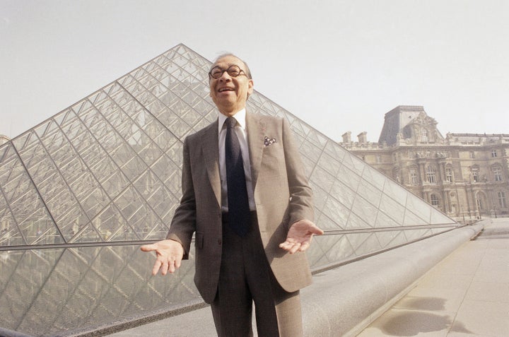 Chinese American architect I.M. Pei bursts out laughing while posing in front of the Louvre glass pyramid, prior to its inauguration on Mar. 29, 1989, in Paris.