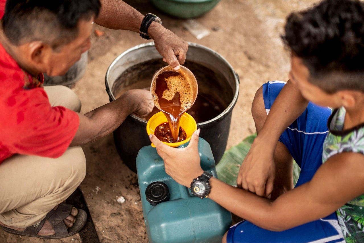 Un chamán vierte la ayahuasca en una garrafa en Pucallpa, Perú.