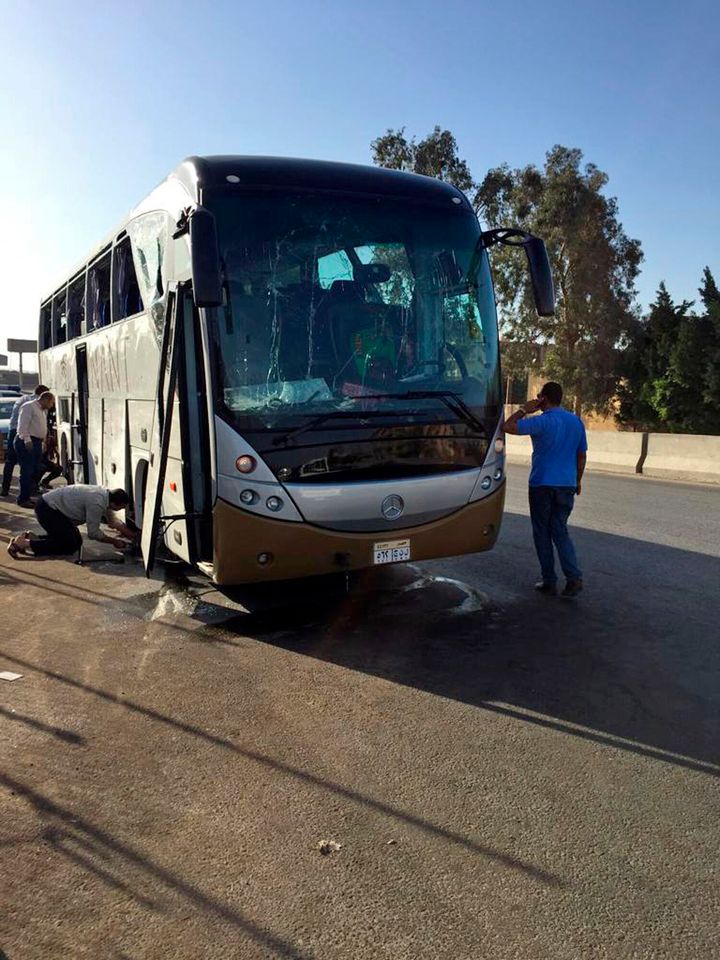 Officials inspect a car and a bus that were damaged by a bomb in Cairo, Egypt, on Sunday. At least 17 people were wounded, including tourists.
