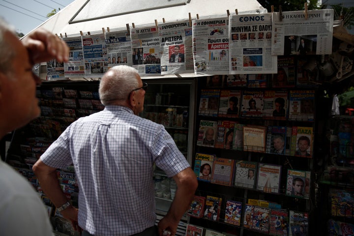 Aθηναίοι διαβάζουν τα πρωτοσέλιδα την επομένη των Ευρωεκλογών, στις 26 Μαϊου 2014.