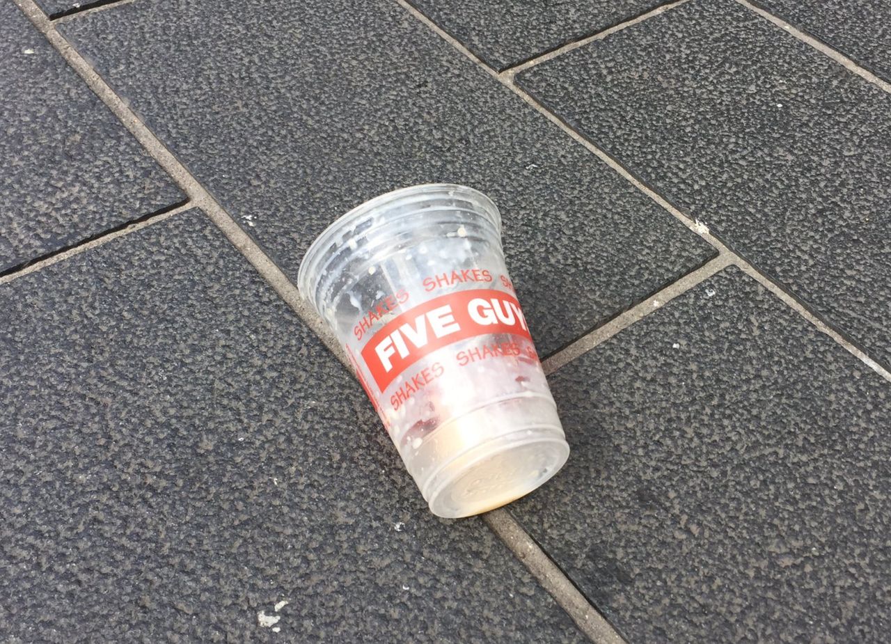 A Five Guys milkshake is left discarded on a Newcastle street after it was thrown over Nigel Farage.