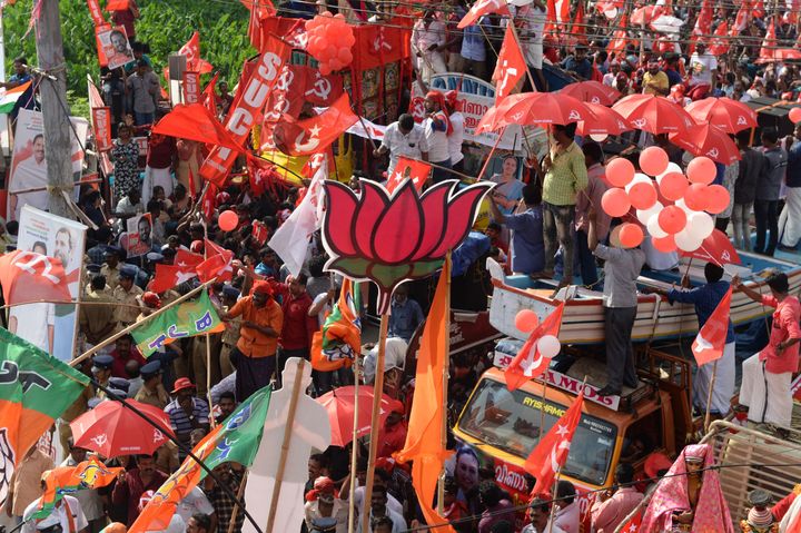 Supporters of BJP, Congress and CPI celebrate in front of each other during the final day of election campaigning in Pathanamthitta, Kerala.