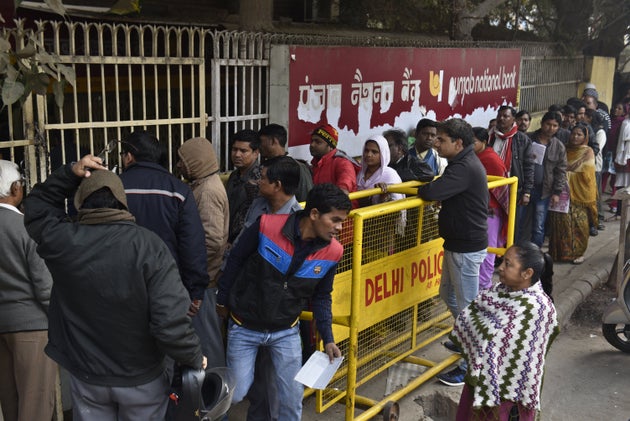 People queue up in front of Punjab National Bank to withdraw or deposit the money at Trilok Puri on December...