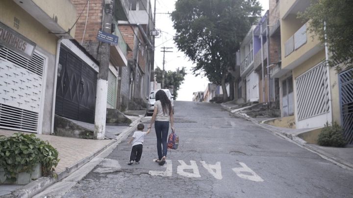 Vanderl&eacute;a Ferreira's 13-year-old daughter, Sabrina, picks up her brother from day care so Ferreira can go to work.