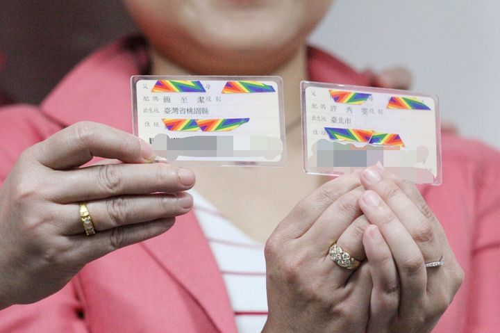 IDカードを手にする許秀雯さんと簡至潔さん。台湾では14歳以上の市民は、父親や母親、配偶者、居住地などの情報が書かれたIDカードを持つ。
