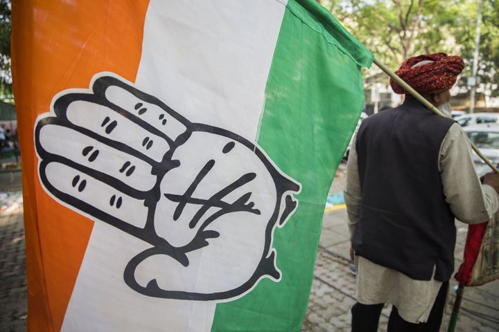 A supporter carries a Indian National Congress Party (INC) flag outside the party's headquarters in New Delhi, India, on Thursday, May 23, 2019.